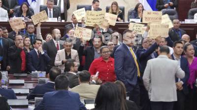 Silbidos y gritos de protesta realizan los diputados del partido Libertad y Refundación (Libre) durante la lectura del informe de la comisión de juicio político en el Congreso Nacional.