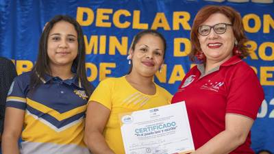 Ciudadana recibe su certificado de alfabetización después de completar el programa.