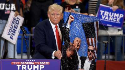 Trump posa junto a una pintura de su icónica foto tras el intento de asesinato en Pensilvania.