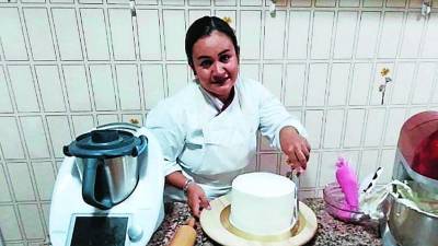 Sara Carolina Meléndez elabora un pastel en la cocina de su departamento; la sampedrana reveló que los productos con mayor demanda son las semitas y los taco flauta que vende congelados.