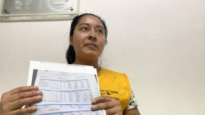 Jenni García, afiliada al IHSS, muestra las copias de las facturas que pagó en una clínica privada por hospitalizar a su hijo con neumonía.