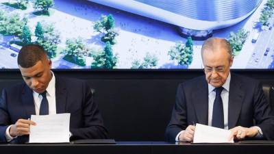 Momento donde Mbappé firma contrato junto al presidente Florentino Pérez.