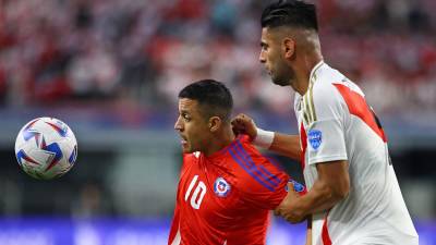 Alexis Sánchez de Chile protege el balón de la marca de Carlos Zambrano de Perú.