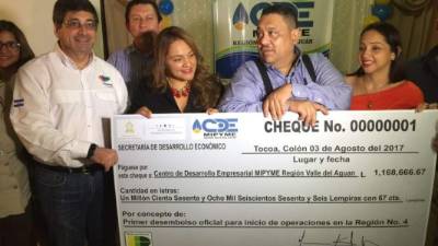 Directivos del CDE con el cheque representativo.