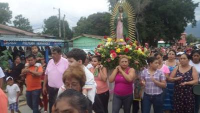 Feligreses cargando la imagen de la virgen.