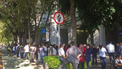 MEX04. CIUDAD DE MÉXICO (MÉXICO), 19/07/2018.- Personas permanecen fuera de los edificios hoy, jueves 19 de julio de 2018, en Ciudad de México (México). Un sismo con magnitud preliminar de 5,9 con epicentro en el sureño estado de Oaxaca disparó hoy la alerta sísmica en Ciudad de México, sin que hasta ahora se reporten víctimas o daños materiales. El Servicio Sismológico Nacional (SSN) ubicó el epicentro del temblor, que se produjo a las 08.31 hora local (13.31 GMT), a nueve kilómetros al noroeste de Huajuapan de León, Oaxaca. EFE/Alex Cruz   
