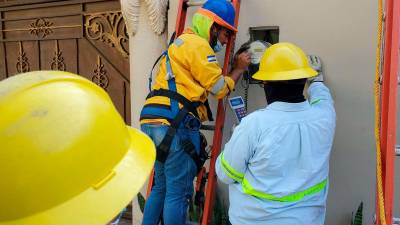 Cuadrilla. Equipos de la Enee y la EEH siguieron revisando medidores ayer en una residencial sampedrana.