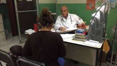 El pediatra endocrinólogo Óscar Zúñiga brinda consulta a una madre de familia que tiene en tratamiento a su hijo.