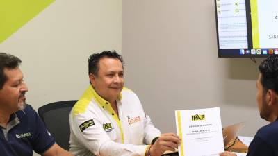 Jorge Encinas, instructor senior de Ipaf, entrega a los ejecutivos de Reimsa el certificado de afiliación.