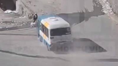 El bus arrolla a una persona que lleva un saco blanco en sus manos.