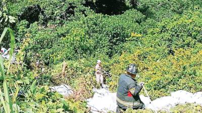 <b><span class=mln_uppercase_mln>Bomberos sacando a los lesionados en el accidente de ayer en la CA-4, en Santa Rosa de Copán; así quedó la rastra.</span></b>
