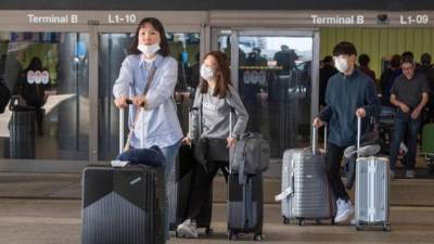 Pasajeros llegando este domingo procedentes de Asia al aeropuerto internacional de Los Ángeles en California. Foto: AFP