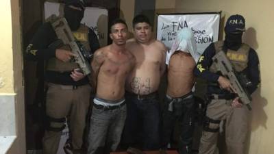 Los tres detenidos son custodiados por agentes de la Fuerza Nacional Antiextorsión (FNA).