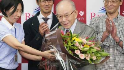 El profesor de la Universidad Meijo Isamu Akasaki recibe un ramo de flores durante una conferencia de prensa en la Universidad de Nagoya el 7 de octubre de 2014. AFP