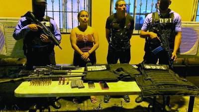 Los detenidos con los fusiles AR-15, los chalecos antibalas, la escopeta y las otras evidencias que les decomisaron.