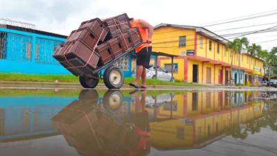 Un hombre transporte cajas de refresco por la calle principal de la colonia Céleo Gonzáles.