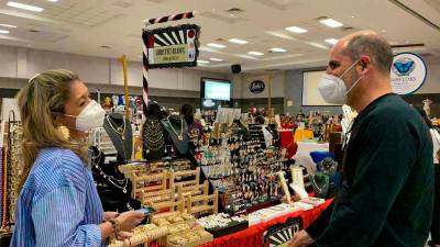 Esfuerzo. Una emprendedora muestra su joyería a Eduardo Facussé, presidente de la CCIC.