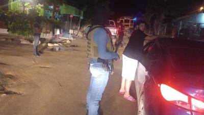 Agentes de la Policía inspeccionan un vehículo y a su conductor.