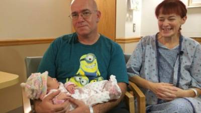 Los sorprendidos padres junto a la bebé que pesó más de 8 libras al nacer.