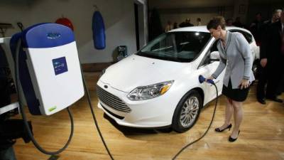 Ejecutiva china muestra un carro eléctrico.