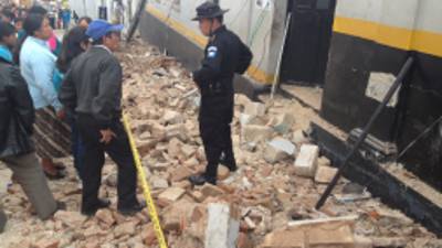 People talk to a police officer while standing in the rubble caused after a magnitude 7.4 earthquake struck in San Marcos, Guatemala, Wednesday, Nov. 7, 2012. The mountain village, some 80 miles (130 kilometers) from the epicenter, suffered much of the damage with some 30 homes collapsing in its center. There are three confirmed dead and many missing after the strongest earthquake to hit Guatemala since a deadly 1976 quake that killed 23,000. (AP Photo/Moises Castillo)