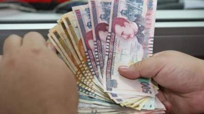 Una hondureña cuenta lempiras en un banco nacional.