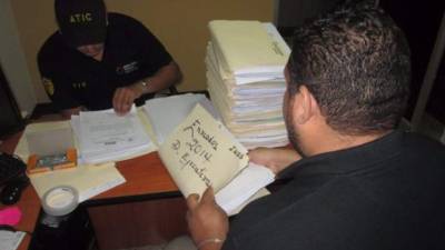 Agentes de la Atic revisan documentación del IHSS en el barrio Abajo de Tegucigalpa.