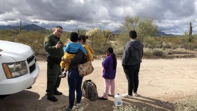 Agente de la patrulla fronteriza habla con una inmigrante hondureña junto a sus tres hijos de 2, 9 y 14 años en la frontera de Arizona con México.