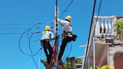 Personal de la Enee trabajando en el mantenimiento de una línea de media tensión.