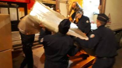 Policias franceses ayudan a transportar los objetos rescatados.
