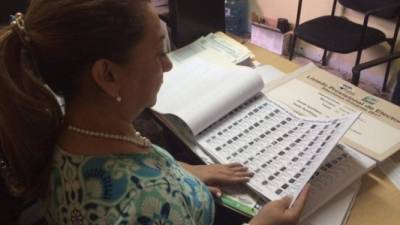 Elizabeth Ávila, registradora civil, revisa los listados electorales. Los tomos están clasificados por apellidos.