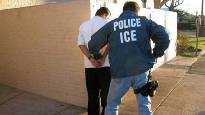Agente de ICE detiene a un inmigrante.