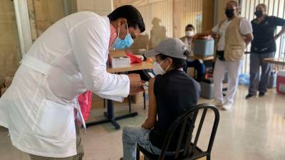 atención. Roberto Cosenza, viceministro de Salud, inmuniza a una niña de 12 años en la Gran Central Metropolitana de San Pedro Sula.