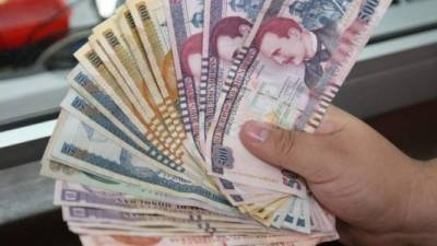 Un hondureño cuenta lempiras en una entidad bancaria.