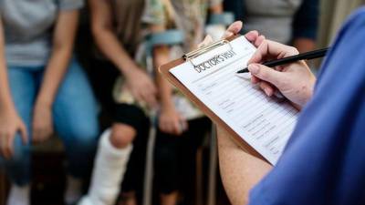 Un médico dándole asistencia médica a un menor.