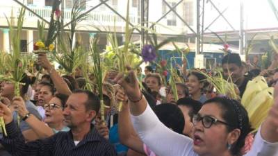 Cientos de feligreses congregados para recibir el agua bendita a las palmas que fueron traídas de la montaña de El Merendón.