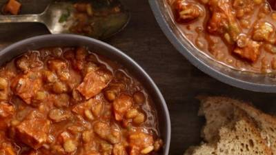 Servir las lentejas repartiendo las costillas en platos hondos.