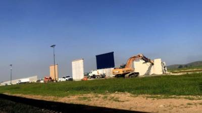 Maquinaria derrumba uno de los ocho prototipos del muro fronterizo entre México y Estados Unidos, en Tijuana (México). EFE