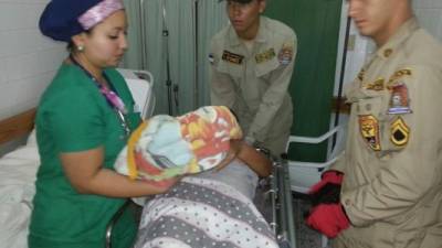 Una enfermera pone a la bebé en manos de su madre, por primera vez, después del parto.