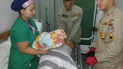 Una enfermera pone a la bebé en manos de su madre, por primera vez, después del parto.