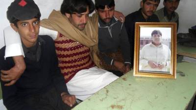 El hermano de Aitizaz Hasan, Mujtaba Hasan (2-i), posa junto a varios compañeros y una fotografía de su hermano en Hangu (Pakistán) hoy, viernes 10 de enero de 2014. Aitizaz Hasan murió el lunes cuando impidió a un atacante suicida detonar el chaleco que portaba cargado de explosivos en un colegio. El Gobierno paquistaní considera otorgar al joven el máximo galardón al mérito civil. Las redes sociales y los medios de comunicación paquistaníes ya homenajeaban ayer al estudiante Aitizaz Hasan. El suceso ocurrió en el distrito de Hangu, en el noroeste de Pakistán, mientras el joven permanecía castigado en el exterior del colegio junto a dos compañeros por haber llegado tarde a clase, dijo el hermano de Aitizaz, Mujtaba, al diario local 'Express Tribune'. EFE