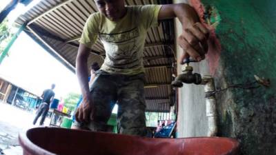 Los vecinos de la colonia Luz del Mundo tienen que ir a otras colonias a recoger agua en baldes de plástico por las carestía. Fotos: Wendell Escoto y Franklyn Muñoz