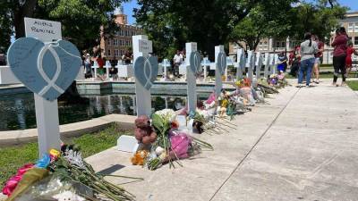 Personas visitan hoy las cruces instaladas en memoria de las 21 víctimas asesinadas el martes en la masacre de la escuela primaria Robb.