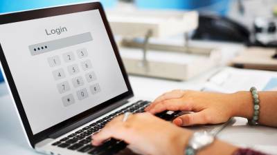 Una persona escribe la contraseña de su laptop.