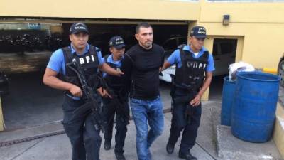 Los agentes de la DPI trasladan al supuesto cabecilla de la banda de robacarros.