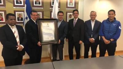 David Matamoros Batson, presidente del TSE, entrega al presidente Juan Orlando Hernández la credencial que le acredita como presidente reelecto de Honduras.