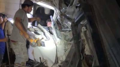 Cuerpos de bomberos realizan labores de rescate tras el accidente de un camión que se estrelló contra una vivienda en Taulabé, liberando a las personas atrapadas.