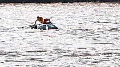 El miembro del Cuerpo de Bomberos inspeccionó el carro que fue arrastrado por al río Cangrejal.
