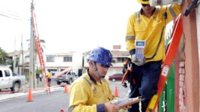 Empleados de la empresa colombiana leen medidores en la capital de Honduras.