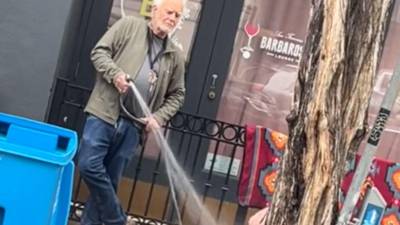 El video del hombre rociándole agua al indigente ha causado indignación en las redes sociales.